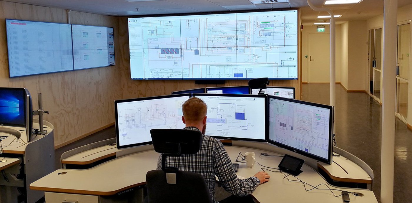 Mann sitter ved skjermer ved Universitetet i Bergen sin nye driftssentral