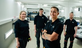 Fire ansatte i GK med arbeidsklær i teksnik rom